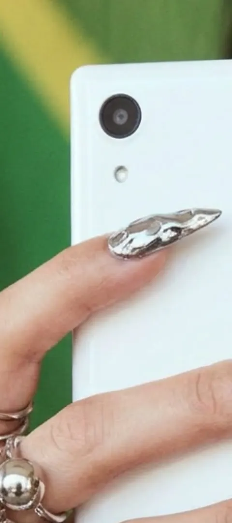 Close-up of the Caytonia camera, held by a hand with a chrome nail