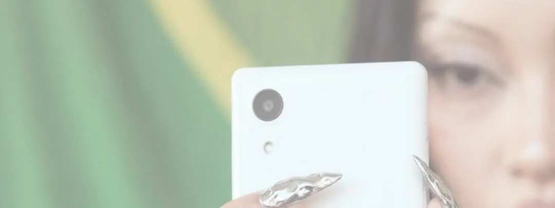 Person holding the white Caytonia Phone in front of a green and yellow background